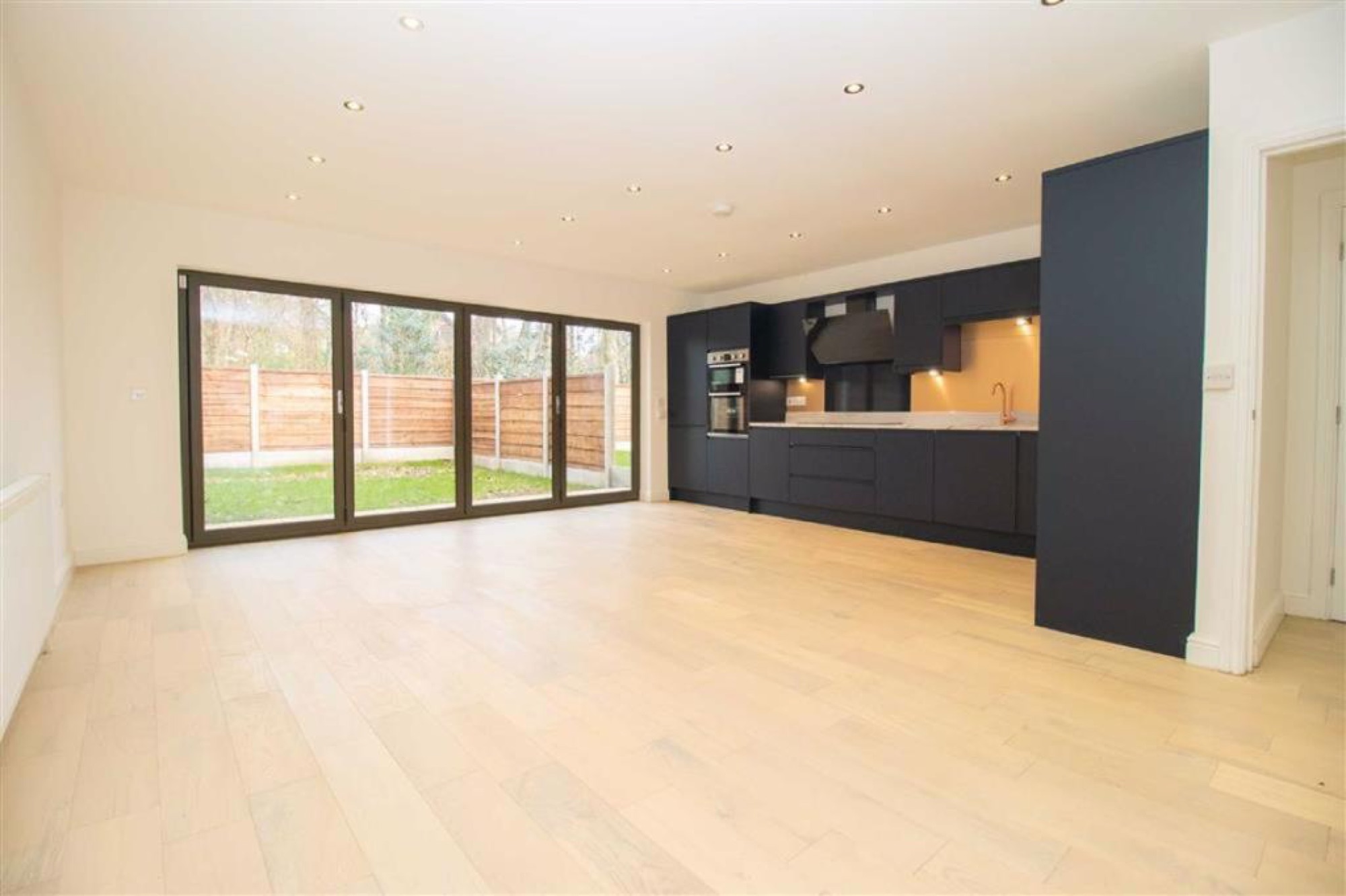 Open-plan kitchen opening to the garden through bi-fold doors
